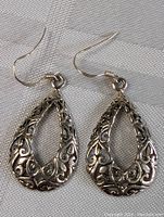 Close-up image of the front side of the pair of vintage sterling silver earrings showing detailed filigree teardrop design.