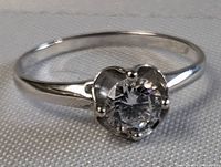 Close-up photo of the sterling silver ring focusing on the clear quartz gemstone set in a four-prong setting, showing the polished band and gemstone clarity.