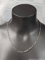 Front view of the necklace displayed on a black mannequin, showing full 20 inch length and chain links.