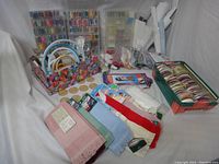 Wide shot displaying all items: embroidery floss boxes, hoops, fabric pieces, and other accessories.