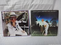 Front covers of Elton John's Greatest Hits I and Greatest Hits Volume II vinyl albums showing cover artwork.