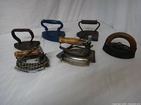 Overview of six vintage irons showing different handle types and materials.