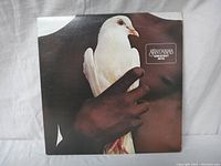 Front cover of Santana's Greatest Hits featuring a close-up of a person holding a white dove.