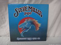 Photo of the front cover of the Steve Miller Band Greatest Hits 1974-78 vinyl record showing the album art with a blue background and stylized horse head logo.