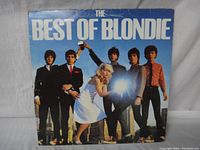 Front cover of The Best of Blondie vinyl album showing band members standing with a bright light flash effect.