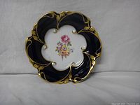 Front view of the dish showing cobalt blue and gold trim with floral center.