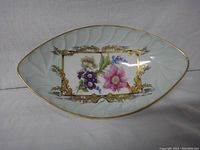 Front view showing the floral design and gold accents on the white porcelain dish.