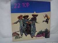 Front cover of ZZ Top El Loco vinyl album, featuring band members in sombreros and denim with colorful text.