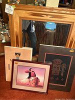 Wide shot of mirror with three framed Native American artworks showing varied tribal themes.