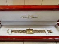 Front view of open red lacquered presentation box showing watch and extra links