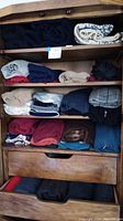 Wooden shelf with folded assorted sweaters in various colors