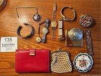 Overview of 5 watches plus 7 accessories laid on wood surface