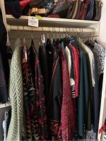 Clothing rack showing assorted women’s size small-medium garments on hangers.