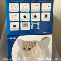 Front and side view of the blue and white box packaging prominently showing the cat door one in cat-head shape with ear-like points and usage instructions on the box.