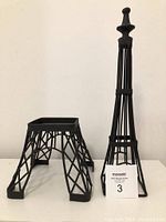 Black metal Eiffel Tower candle holder showing separated top and base parts.