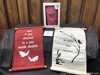 Two fabric scrolls and a boxed light-up lantern displayed on a fabric surface, showing overall contents of the lot.