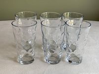 Six of the eight clear glasses arranged in two rows on a table, showing the bubble texture on the glass surface.