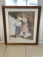 Front view of the framed art print showing the boy and girl walking on a path beside a stone wall.