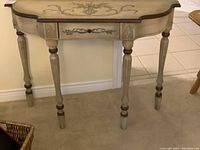 Full view of the wooden hallway table against the wall on carpet flooring, showing the design on the tabletop and legs.
