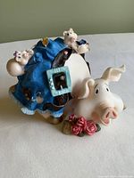 Front view of the large piggy bank showing mother pig with flowers and baby pigs on blue blanket