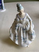 Front view of the Royal Doulton Caroline figurine highlighting the floral details on the dress and the figure's face and posture.