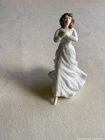 Front view of Royal Doulton Forget-Me-Not figurine showing the figure's face, hair, and flowing white dress.