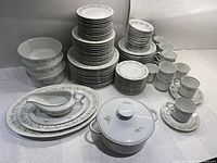 Full set overview showing stacks of plates, bowls, cups, saucers and serving pieces
