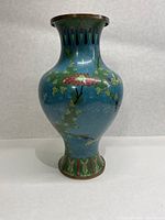 Front view showing blue enamel floral copper vase with minor enamel wear and copper rim and base