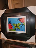 Front view of professionally framed colorful butterfly and flower fine art print by David Morrisseau, showing matted border with artist signature and edition number.