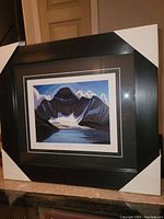 Photo of the professionally framed fine art print showing the mountain and lake scene with the title and artist signature visible.