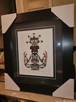 Front view of the professionally framed fine art print "Sun and Serpent" by Chief Henry Speck showing the black frame with protective white corner covers.