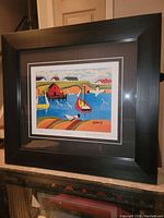 Framed Maud Lewis print on display showing the full frame and artwork titled 'Harbour'.