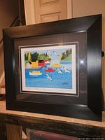 Front view of the professionally framed fine art print showing vibrant coastal scene with boats and seagulls.