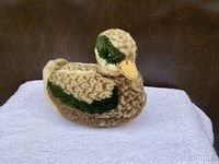 Side view of the small Steiff duck plush toy showing body, colors, and shape