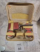 Complete grooming set inside cream leather zippered case showing all pieces secured with leather straps.