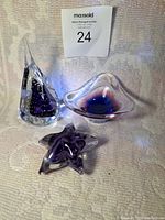 Front view of the three purple glass pieces shown together on fabric background