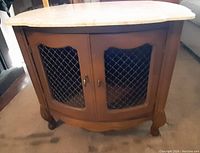 Front view of wooden cabinet with double lattice doors and removable faux marble top.