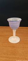 Photo showing the full side view of the small cordial glass with cobalt blue spiral stripes on the clear glass bowl, frosted white stem and base.