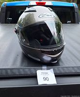 Front view of silver Fox full-face motorcycle helmet placed on a gray surface with clear visor down, showing general condition and Fox branding.