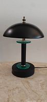 Full view of the black post modern UFO touch lamp with teal accents on base and stem, showing overall design and patina.