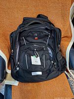 Front view of black Swiss Gear backpack showing multiple compartments and the Swiss Gear logo.