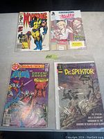 Four comic books including Wolverine, Buffy guide, Batman/Green Arrow, and Dr. Spektor