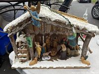 View of the complete nativity set including stable structure, figurines, and lighting