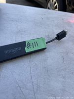 Close-up image of Amazon Fire TV Stick with a green label '#111' and USB-C connector visible.