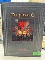 Front cover of 'The Art of Diablo' book showing embossed black hardcover with fantasy demon artwork.