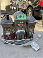 Front view of ceramic Victorian style gourmet chocolate maker building with power cord and label visible