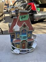 Front view of ceramic Victorian coffee shop showing detailed painting and door with signage. Electrical cord visible coiled at base.