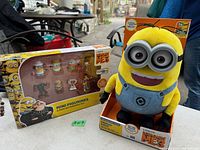 Photo of boxed large Dave Minion plush talking toy and boxed set of five mini figurines from Despicable Me 3.