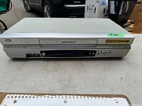 Front view of silver JVC VHS player model HR-VP371, showing tape loading slot, buttons, and ports.