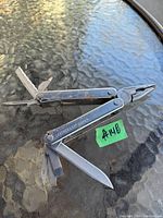 Leatherman Core multitool open showing needle-nose pliers, knife blade, flathead screwdriver, and other tools